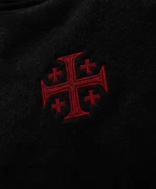 Close-up of the red embroidered Jerusalem cross on the chest